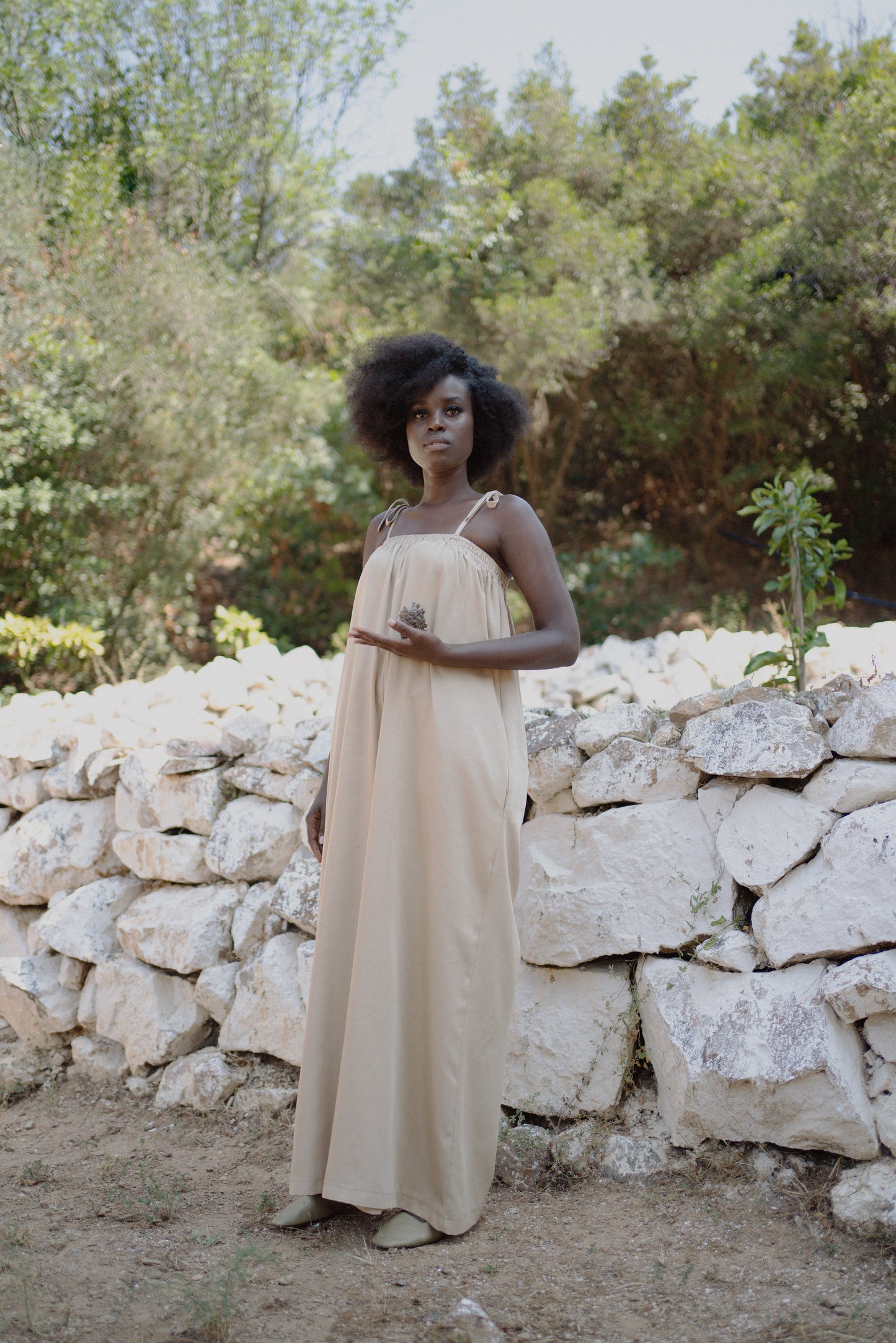 Woman standing wearing a beige jumpsuit