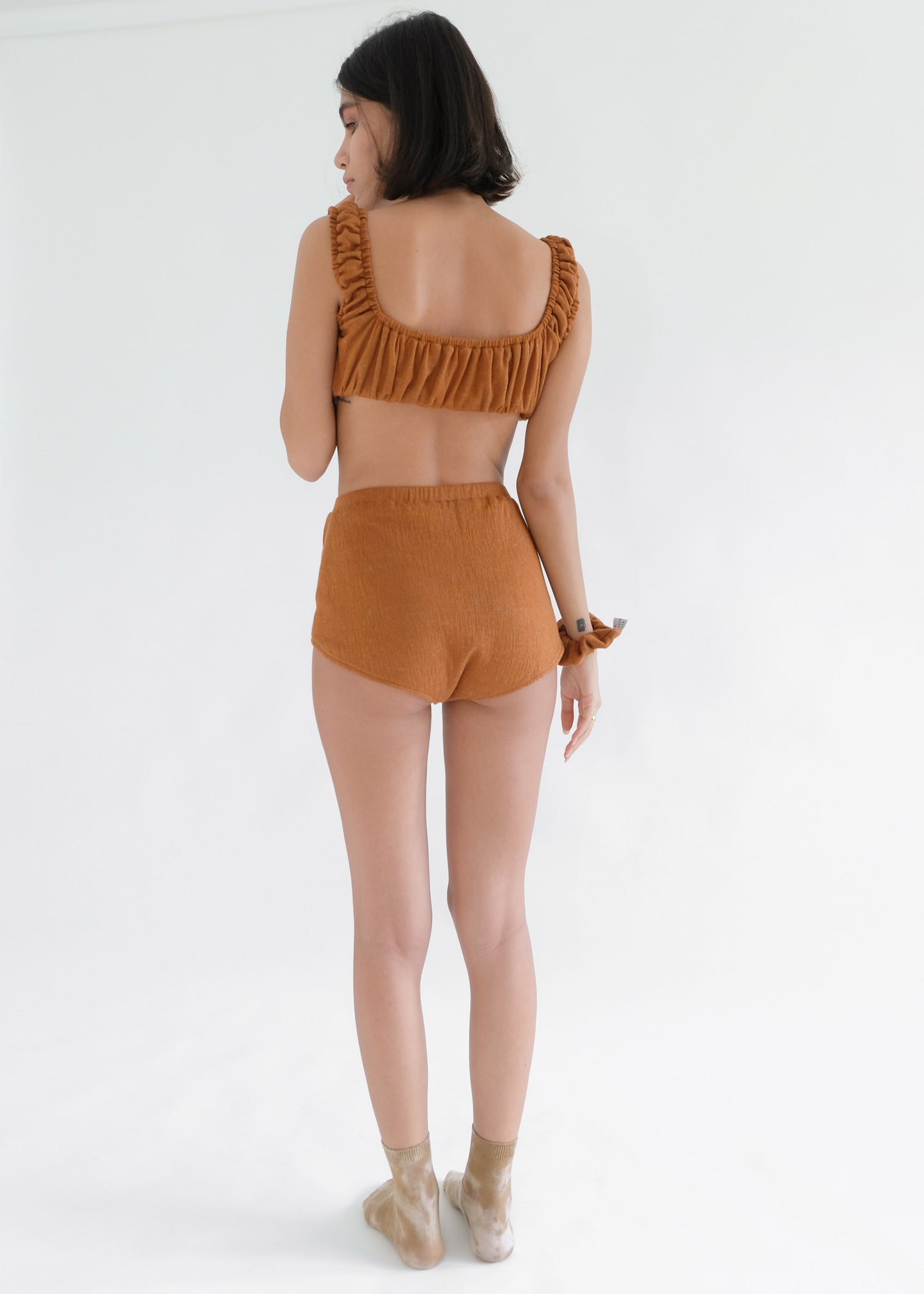 Girl standing backwards wearing brown underwear set