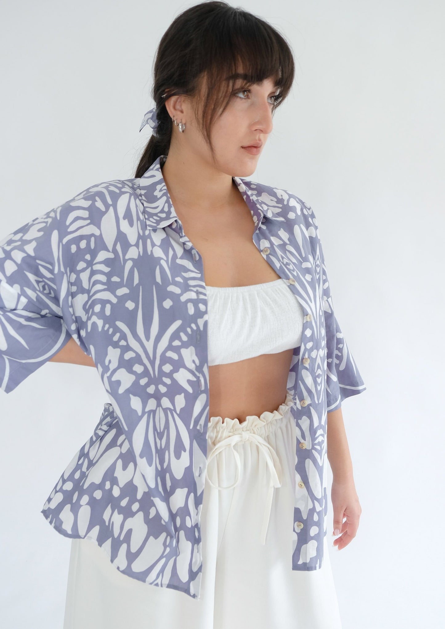 Girl standing wearing cotton blue shirt and white trousers