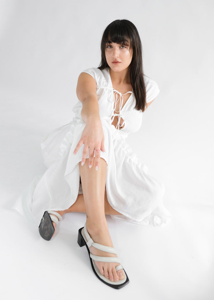 Girl sitting wearing white midi dress