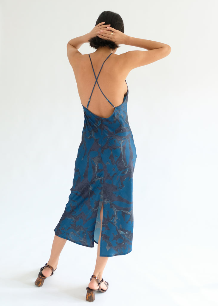 Girl standing backwards wearing blue printed midi dress