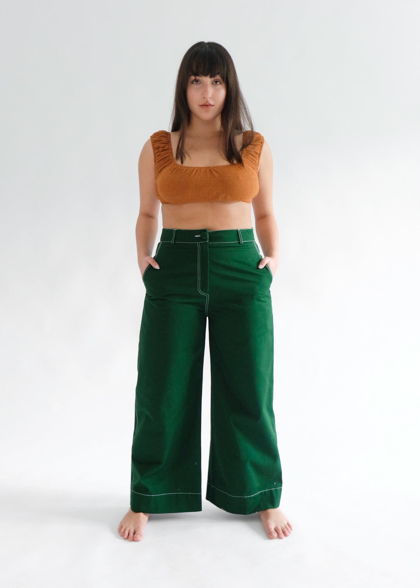 Woman wearing brown crop top with pine green trousers