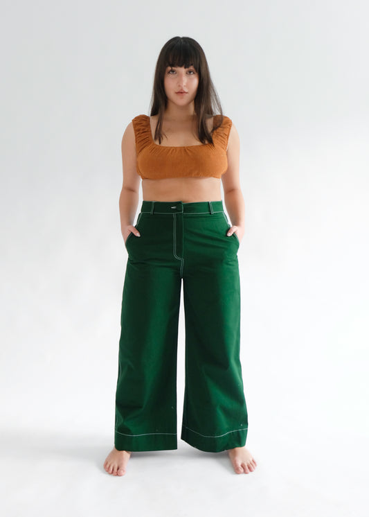 Woman wearing brown crop top with pine green trousers