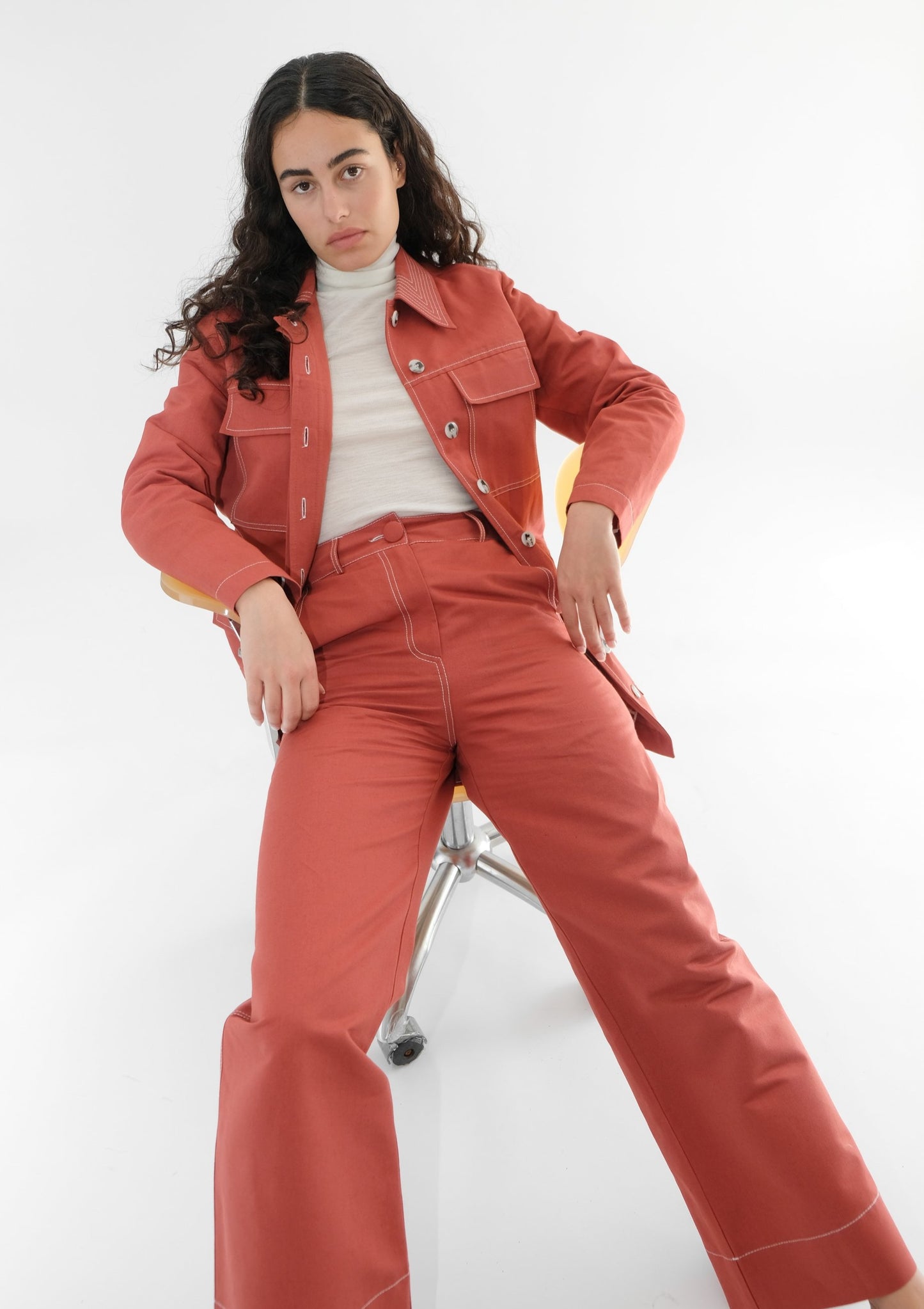Woman wearing red jacket and trousers with white turtleneck underneath