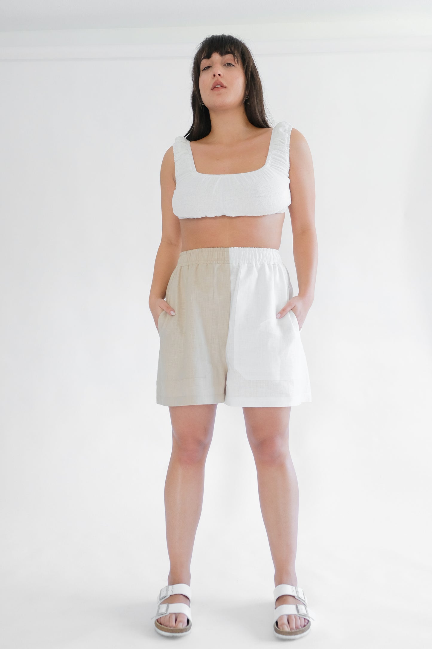 Girl standing wearing white top and shorts