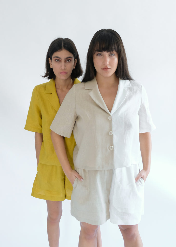 Two girls standing wearing white and brown shirt and short sets
