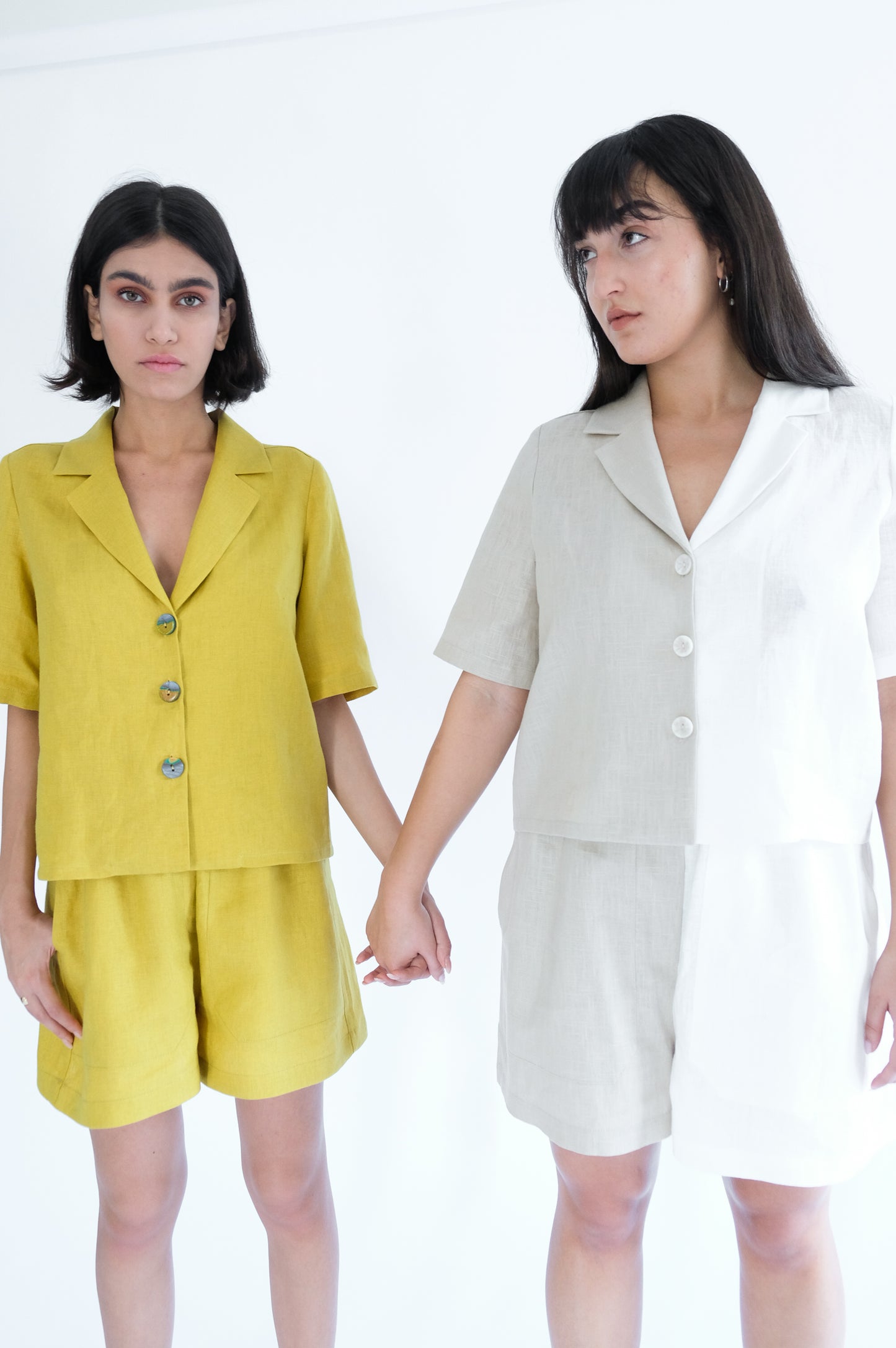Two girls holding hands wearing brown and white shirt and short sets