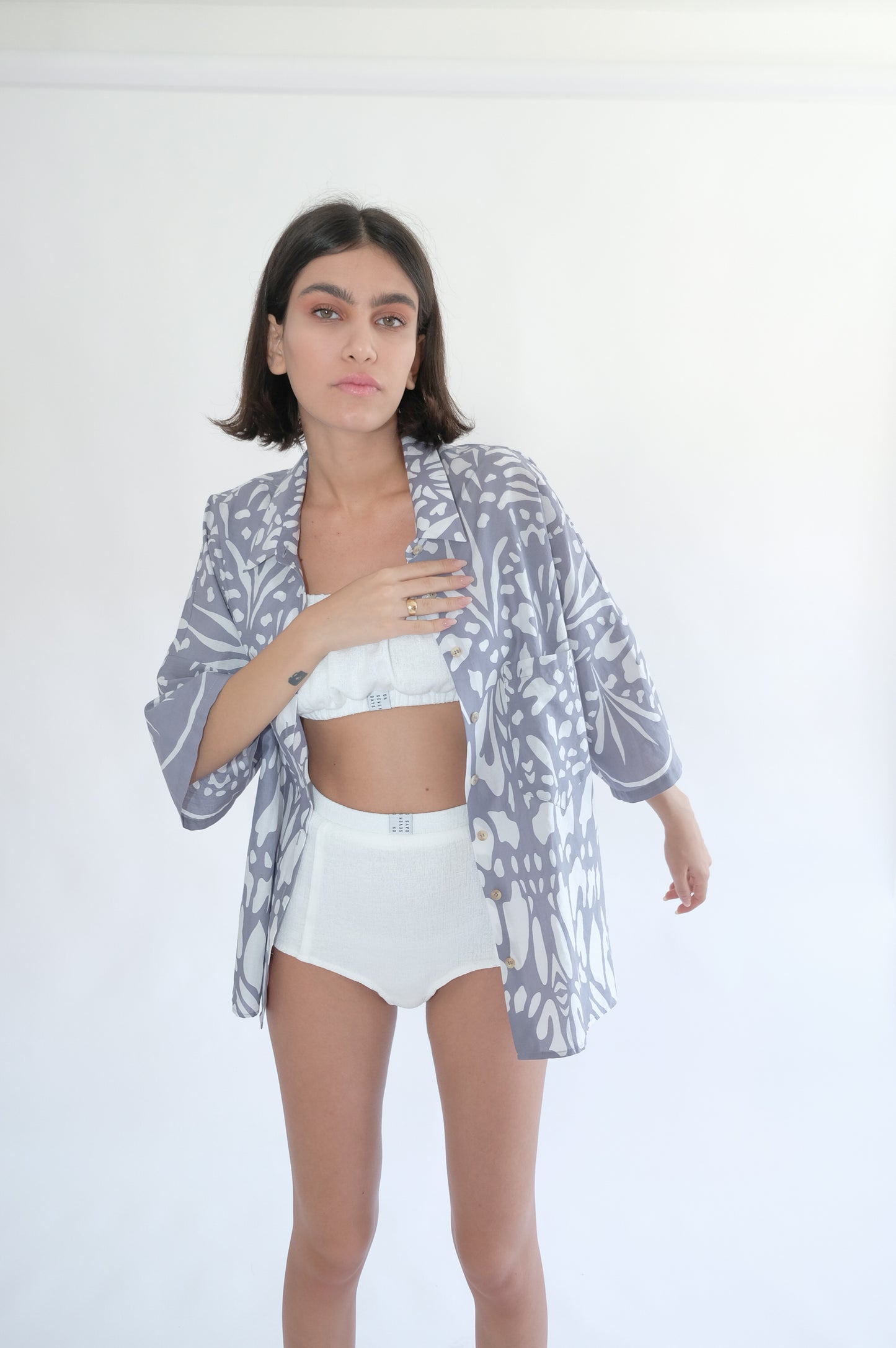 Girl standing wearing white underwear set and blue printed shirt