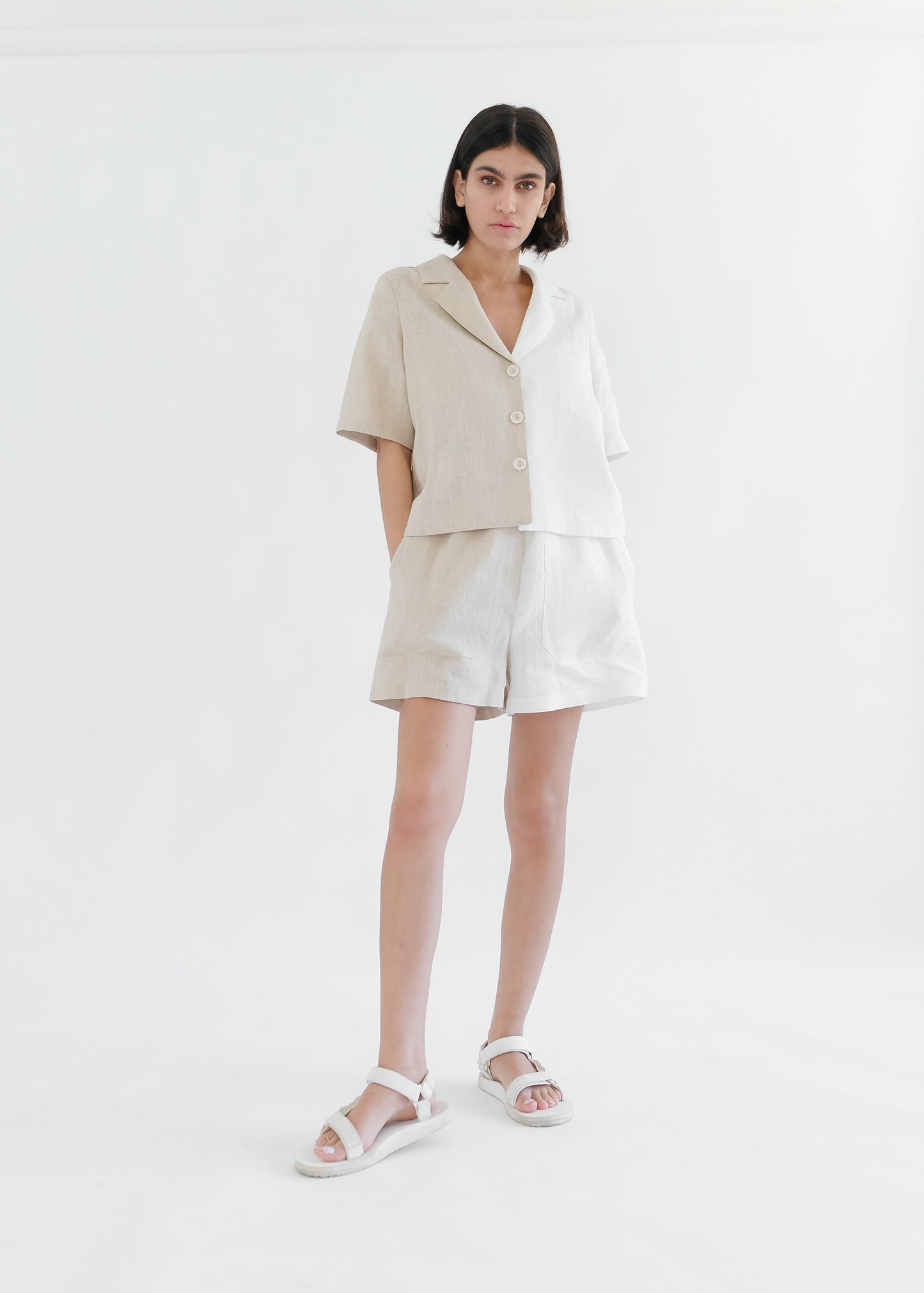 Girl standing wearing white and brown shirt and shorts