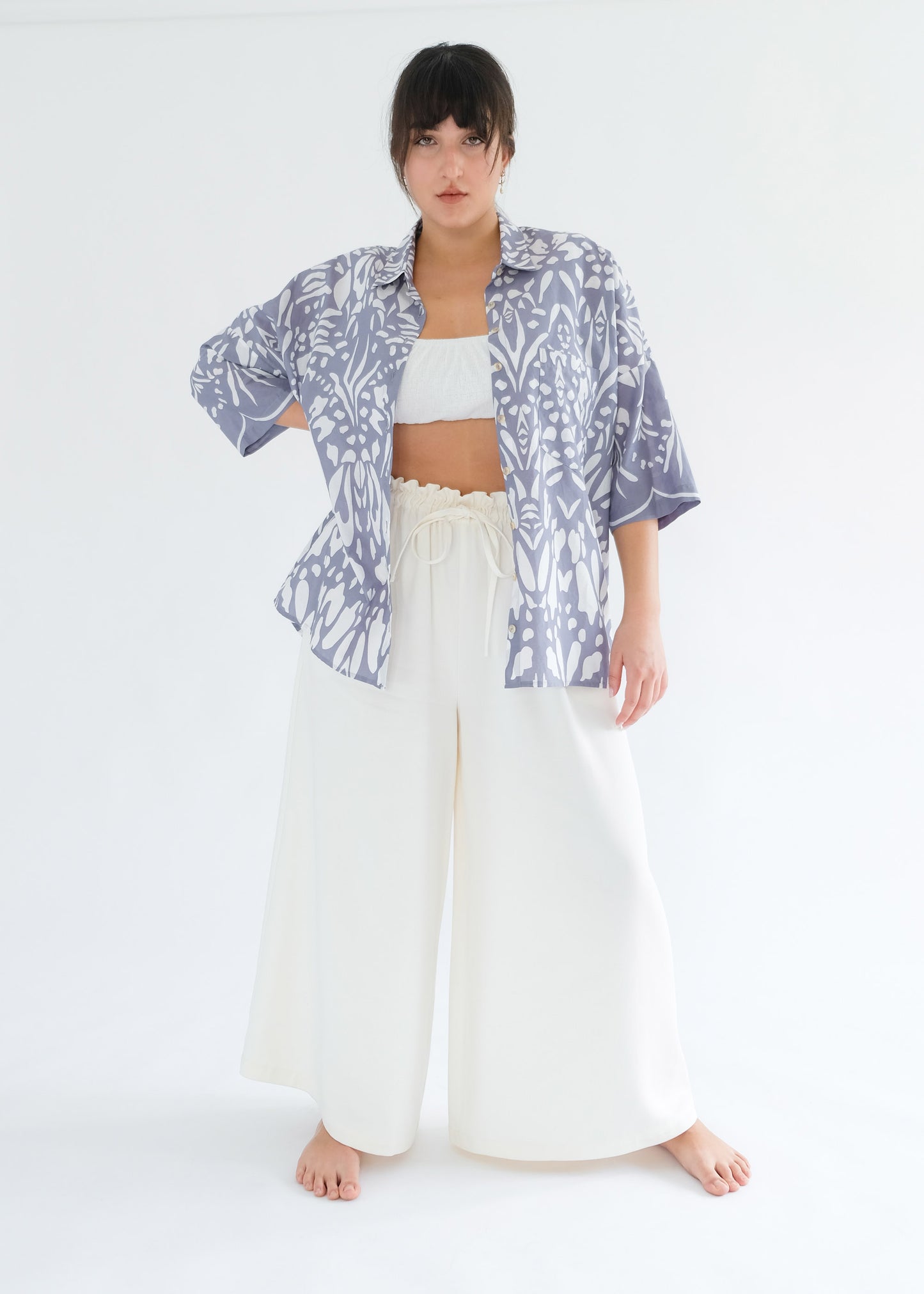 Girl standing wearing cotton blue shirt and white trousers