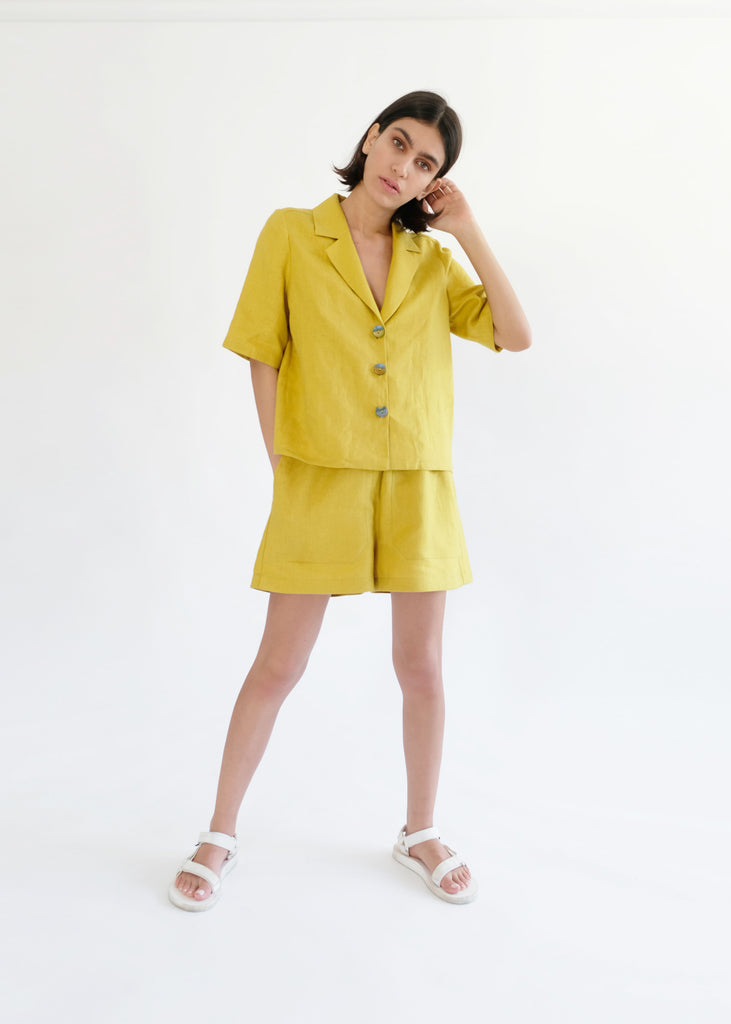 Girl standing wearing yellow shirt and shorts set