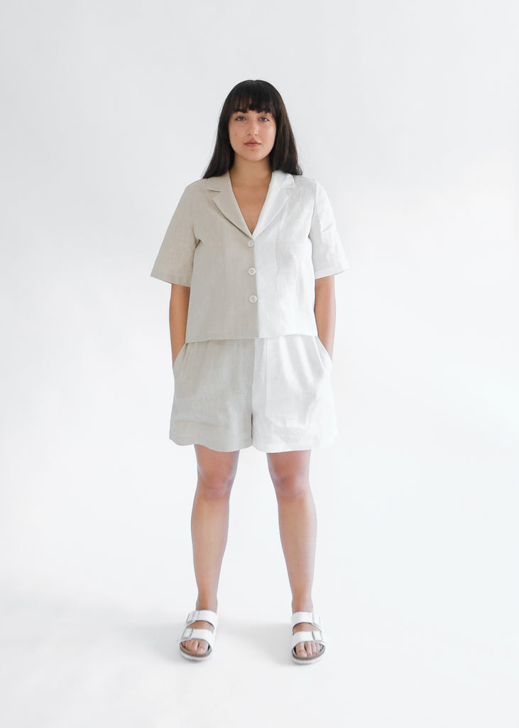 Girl standing wearing brown and white shirt and short set 