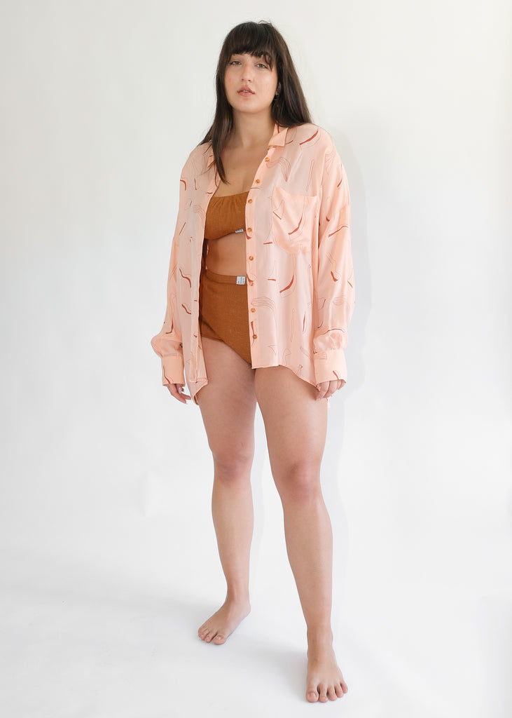 Girl standing wearing silk printed pink shirt and brown underwear set