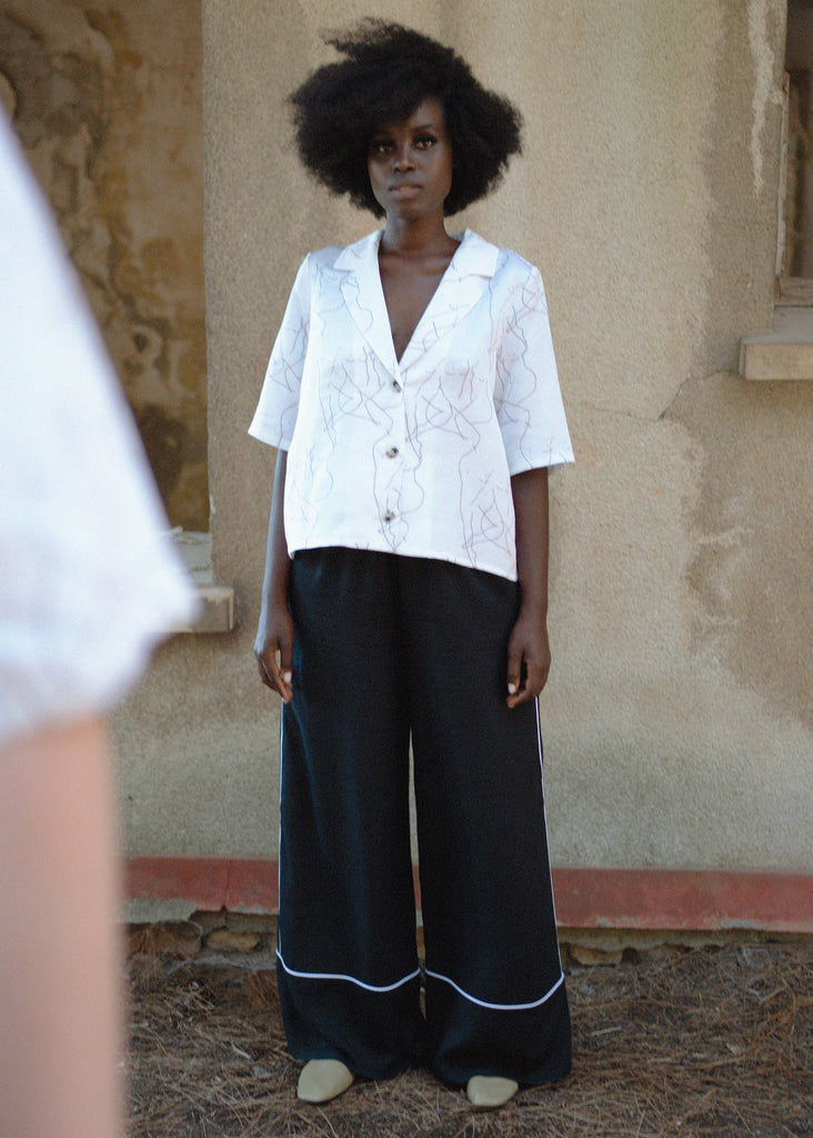 Woman wearing printed white shirt and black trousers