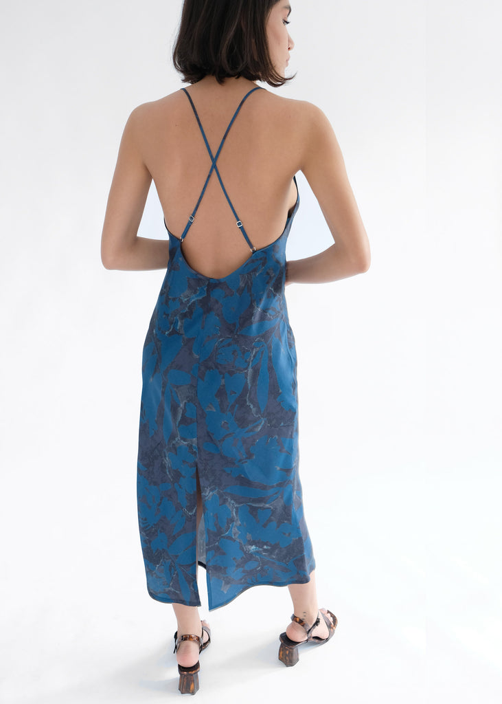 Girl standing backwards wearing blue printed midi dress