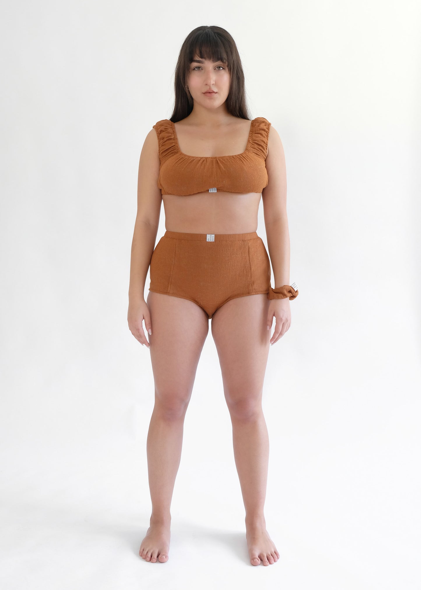 Girl standing wearing brown underwear set 