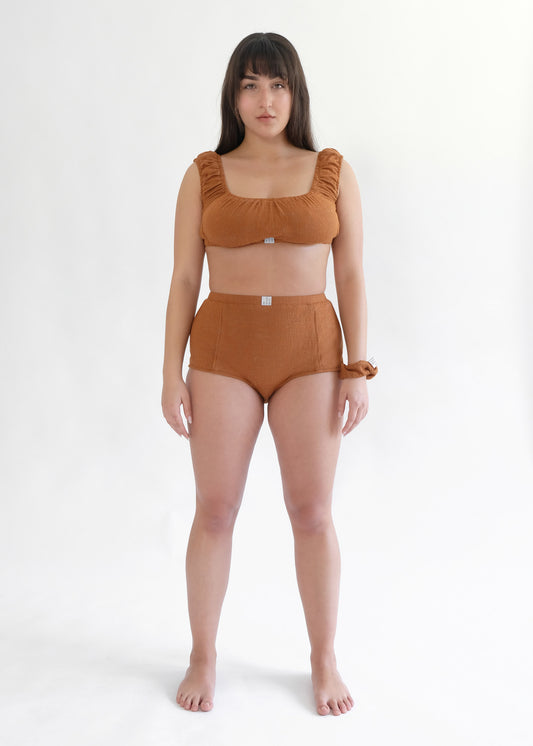 Girl standing wearing brown underwear set 