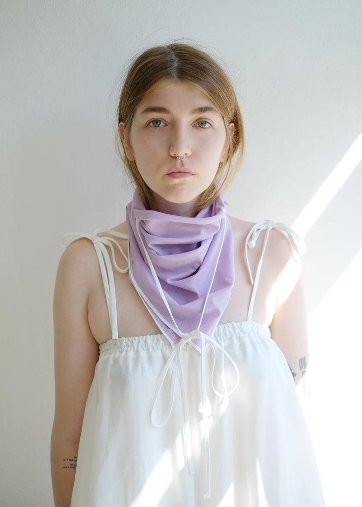 Front view of a girl wearing a purple scarf and white top